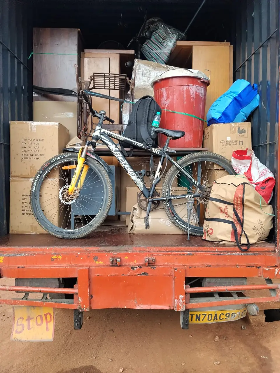 Bike and packed household goods loaded together in a Kerala Road Lines container