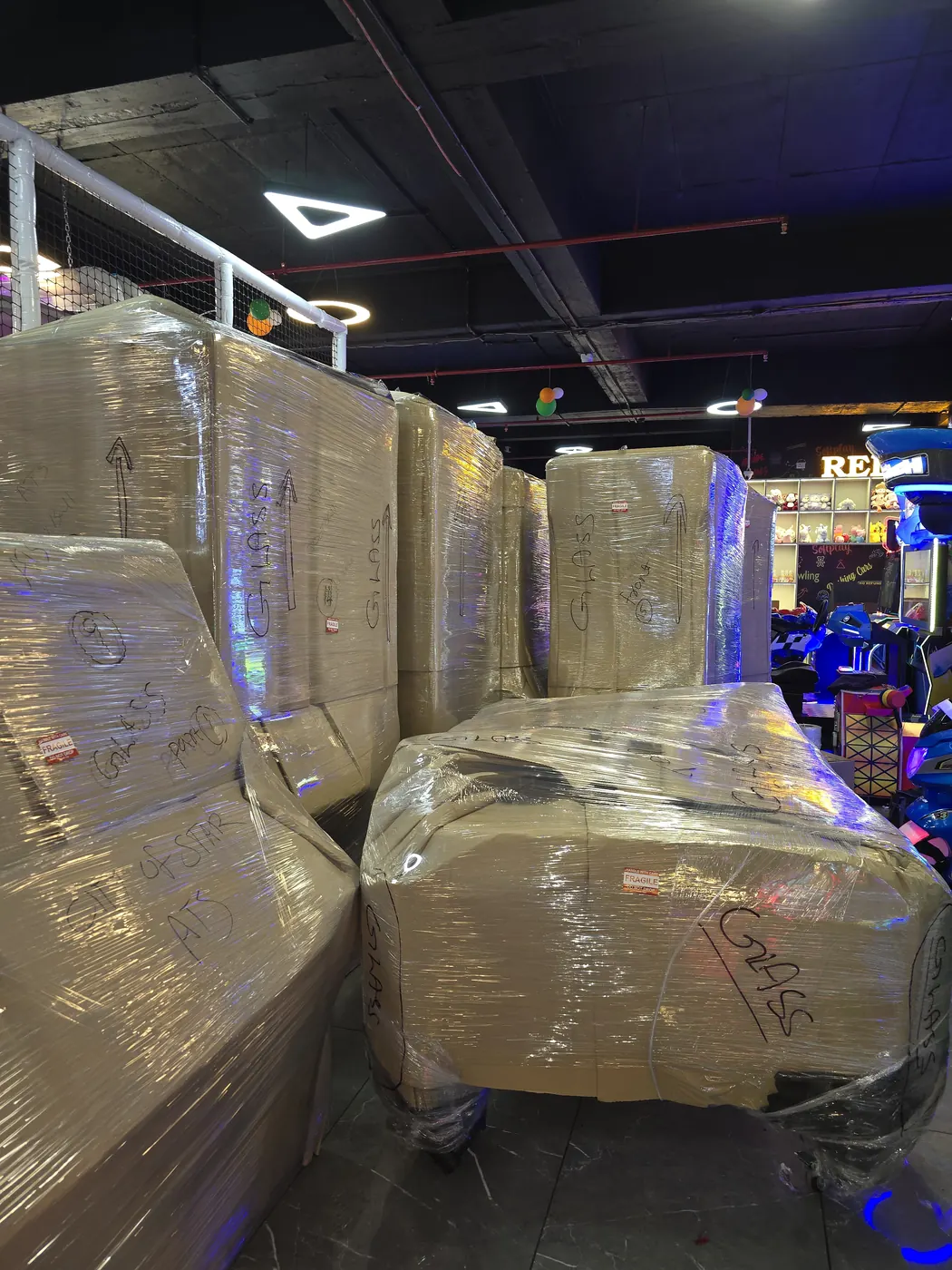 Arcade machines stretch-wrapped and marked GLASS for a commercial relocation
